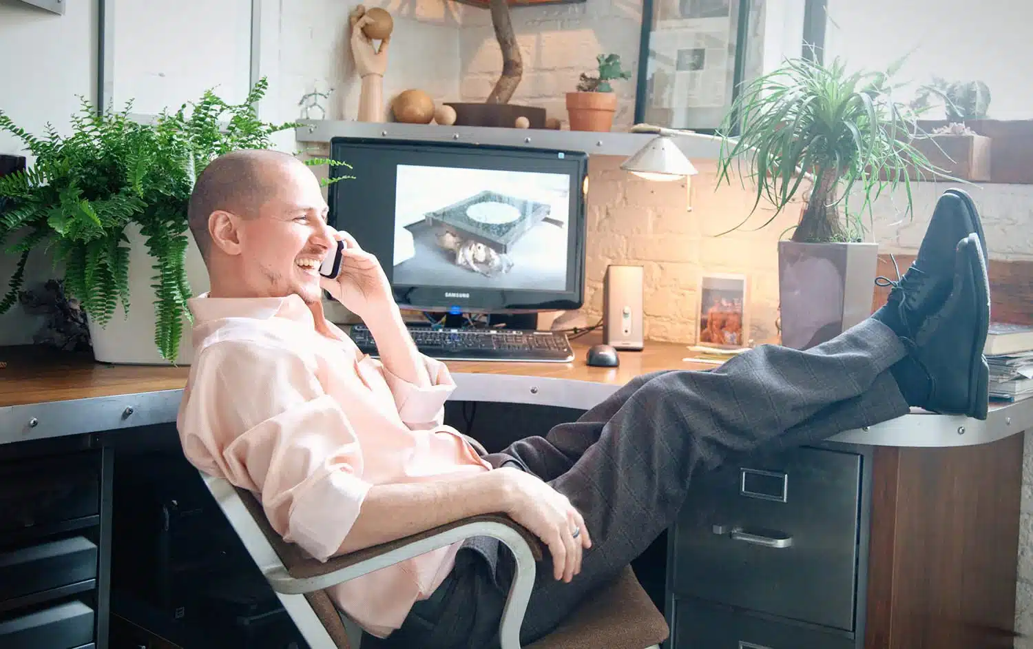 Image of happy employee surrounded with plants and speaking on the phone